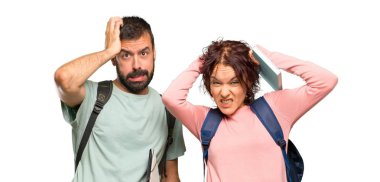 Sırt çantaları ve kitapları olan iki öğrenci, izole beyaz arka planda migreni olduğu için el ele alır.