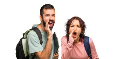 Sırt çantaları ve kitapları ile iki öğrenci ağız ardı nasiaçık bağırArak ve izole beyaz arka plan üzerinde bir şey ilan