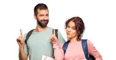 Sırt çantaları ve kitapları ile iki öğrenci gösteren ve izole beyaz arka plan üzerinde en iyi işareti bir parmak kaldırma