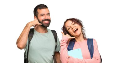 Sırt çantaları ve telefon hareketi yapan kitapları olan iki öğrenci. İzole beyaz arka planda bana geri işaret arayın