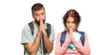 Sırt çantaları ve kitapları olan iki öğrenci avuç içi bir arada tutuyor. Kişi izole beyaz arka plan üzerinde bir şey ister