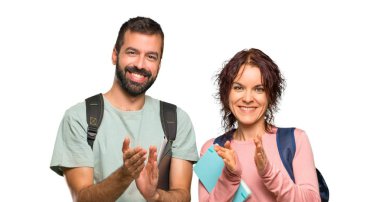 Sırt çantaları ve kitapları ile iki öğrenci izole beyaz arka plan üzerine bir konferansta sunum sonra alkışlayan