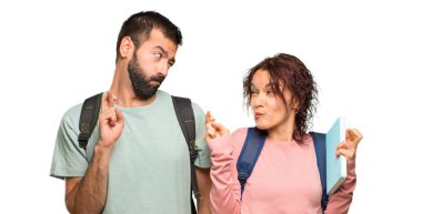 Sırt çantaları ve parmakları geçiş ve izole beyaz arka plan üzerinde en iyi dilek ile kitap ile iki öğrenci