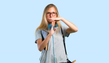 Mavi arka plan üzerinde bir hareket durdurmak için eliyle stop jest yapma gözlüklü öğrenci kız