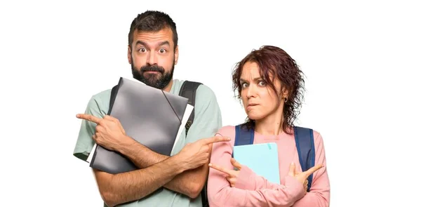 Twee Studenten Met Rugzakken Boeken Wijzend Naar Lateralen Die Twijfelen — Stockfoto