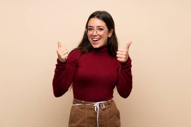 Jest kadar başparmak ve gülümseyen gözlüklü genç kız