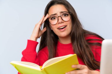 Bir masada okuyan sinirli genç öğrenci kız