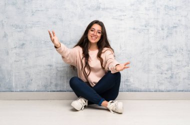 Genç öğrenci kız sunan bir tabloda okuyan ve el ile gelmek için davet