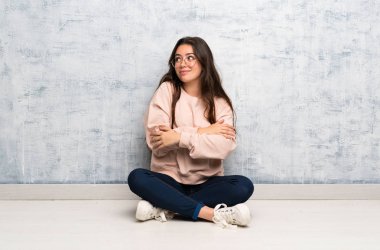 Omuzları kaldırırken şüphe jest yapma bir masada okuyan genç öğrenci kız