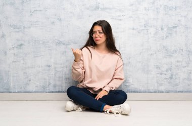 Genç öğrenci kız mutsuz bir masada okuyan ve yan işaret