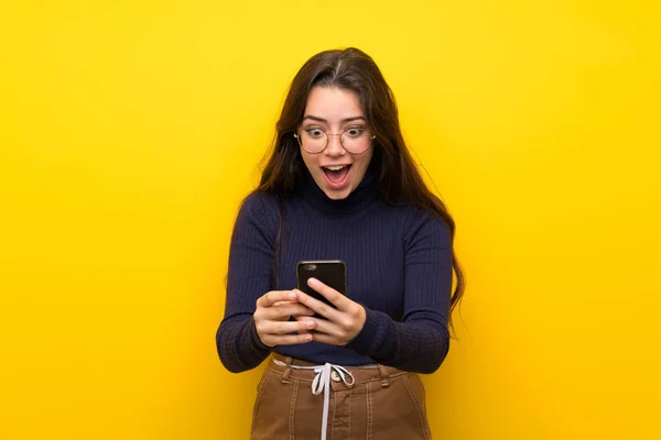 Adolescente Menina Sobre Isolado Parede Amarela Surpreendido Enviando Uma Mensagem — Fotografia de Stock
