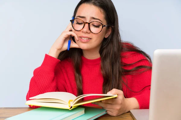 Bir masada okuyan sinirli genç öğrenci kız