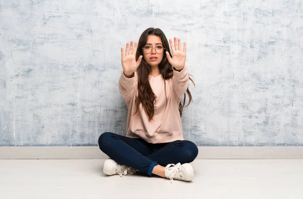Bir masada okuyan genç öğrenci kız dur jesti yapıyor ve hayal kırıklığına uğradı