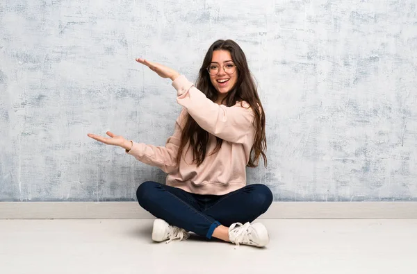 Bir reklam eklemek için copyspace tutan bir tabloda okuyan genç öğrenci kız