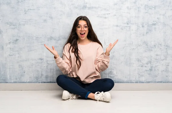 Genç öğrenci kız şok yüz ifadesi ile bir masada okuyan