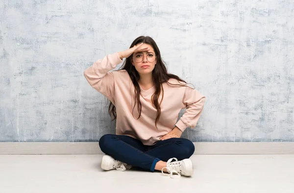 Bir masada okuyan genç öğrenci kız bir şey bakmak için el ile uzak bakıyor