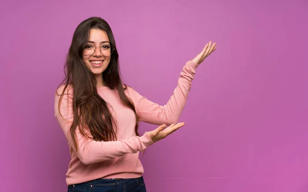 Menina Adolescente Sobre Parede Roxa Estendendo Mãos Para Lado Para — Fotografia de Stock