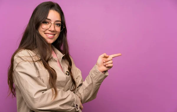 Tiener Meisje Paarse Muur Wijzende Vinger Naar Kant — Stockfoto