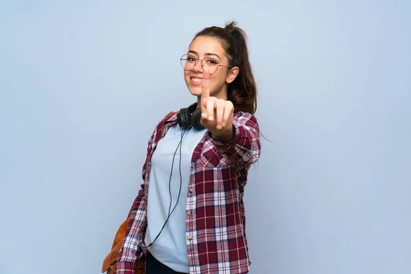 Tiener Student Meisje Geïsoleerde Blauwe Muur Tonen Tillen Van Een — Stockfoto