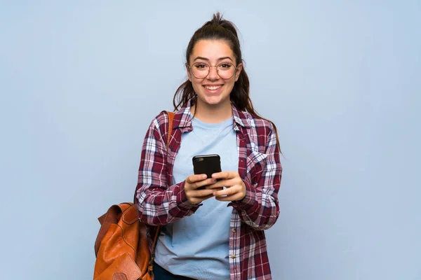 Teenager Student Mädchen Über Isolierte Blaue Wand Senden Eine Nachricht — Stockfoto