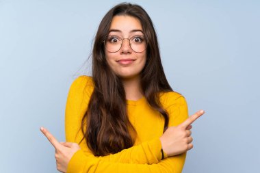 Izole mavi duvar üzerinde genç kız şüpheleri olan laterals işaret