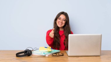Genç öğrenci kız iyi bir anlaşma kapanış için el sıkışma bir masada okuyan