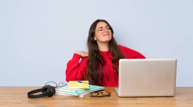 Genç öğrenci kız bir çaba yapmış olduğu için sırt ağrısı muzdarip bir masada okuyan