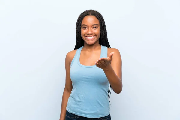 非裔美国青少年女孩与长辫子的头发在孤立的蓝色背景握手后好交易 — 图库照片