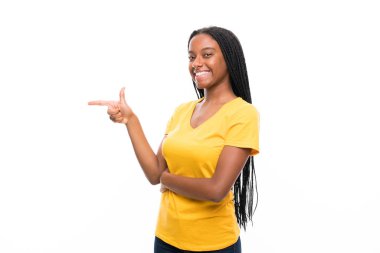 Izole beyaz arka plan yan işaret parmak üzerinde uzun örgülü saçlı Afro-Amerikan genç kız