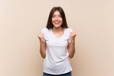 Izole arka plan üzerinde Güzel genç kız kazanan pozisyonda bir zafer kutluyor