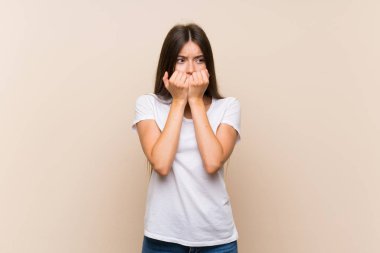 Izole arka plan sinirli üzerinde Pretty genç kız ve ağıza ellerini koyarak korkmuş