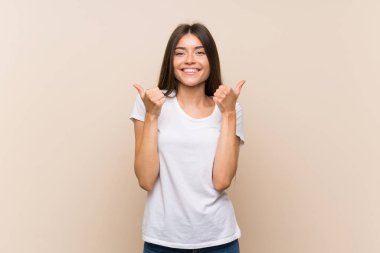 Jest kadar başparmak ve gülümseyerek izole arka plan üzerinde Pretty genç kız