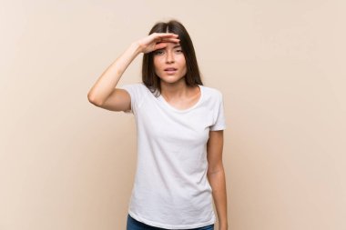 Izole arka plan üzerinde Pretty genç kız uzak el ile bir şey bakmak için bakıyor