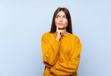 Izole mavi duvar üzerinde Kafkas genç kadın bir fikir düşünme