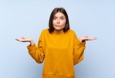 Izole mavi duvar üzerinde beyaz genç kadın yüz ifadesi karıştırarak şüpheleri olan