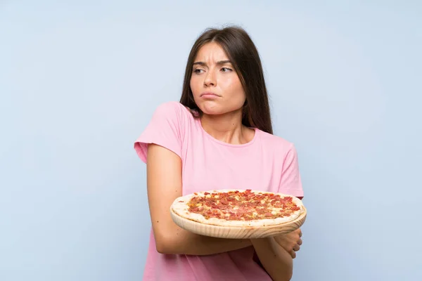 Pretty Young Girl Holding Pizza Isolated Blue Wall Making Doubts — Stock Photo, Image