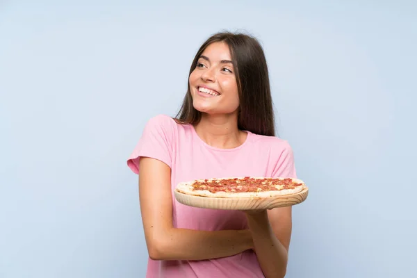 Chica Bastante Joven Sosteniendo Una Pizza Sobre Una Pared Azul — Foto de Stock