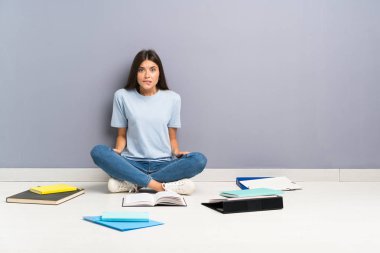 Yerde şüpheleri olan ve yüz ifadesini karıştıran genç öğrenci kadın