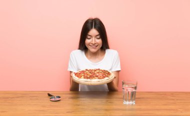 Bir masada pizza ile genç kadın