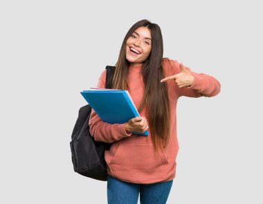 İzole gri arka plan üzerinde dizüstü bilgisayarlar gururla ve kendinden memnun tutan genç öğrenci kadın