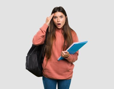 Defter tutan genç öğrenci kadın sadece bir şey fark etti ve izole gri arka plan üzerinde çözüm niyetinde