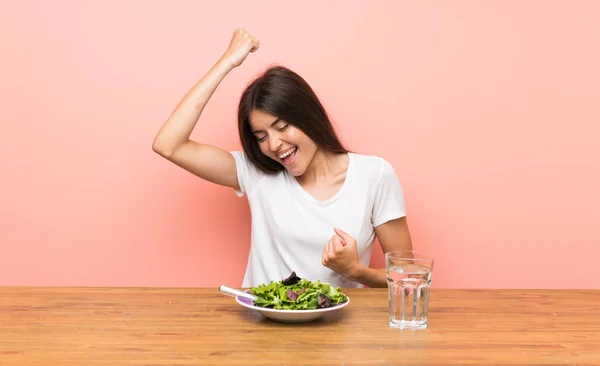 Young woman with a salad celebrating a victory