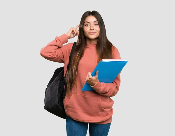 Joven Estudiante Sosteniendo Cuadernos Con Dudas Pensando Fondo Gris Aislado —  Fotos de Stock