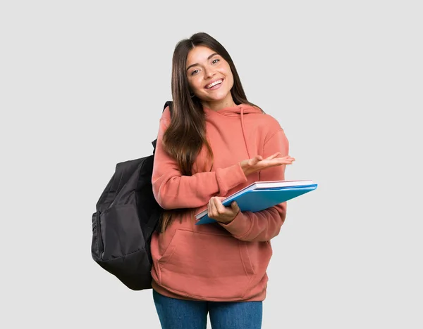 年轻的女学生拿着笔记本 一边微笑着看着孤立的灰色背景 — 图库照片