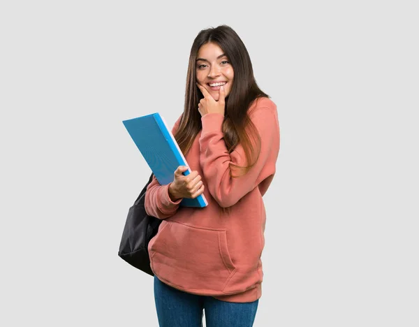 Joven Estudiante Sosteniendo Cuadernos Mirando Lado Sobre Fondo Gris Aislado —  Fotos de Stock