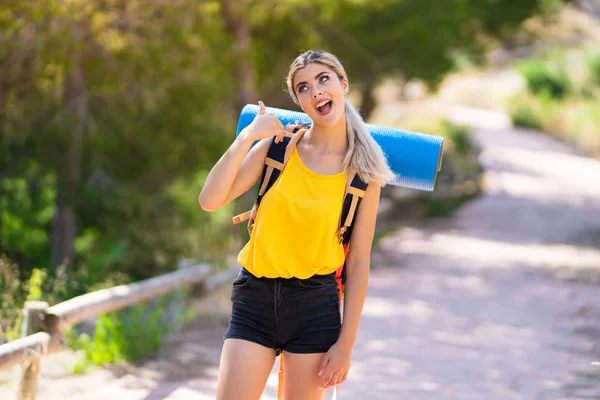 Genç kız telefon jesti yaparak açık havada yürüyüş. Beni geri arayın işareti