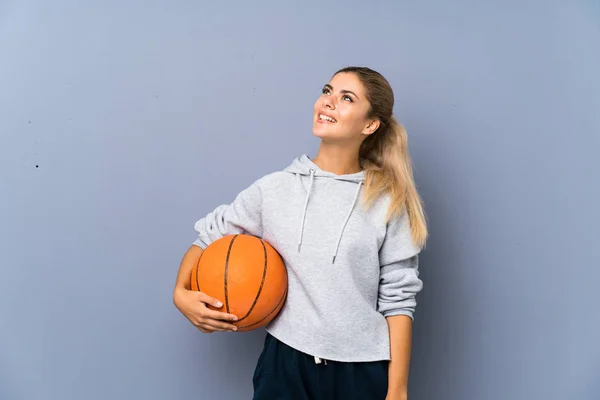 Genç Kız Gülümseyerek Yukarı Bakıyor Gri Duvar Üzerinde Basketbol Oynuyor — Stok fotoğraf