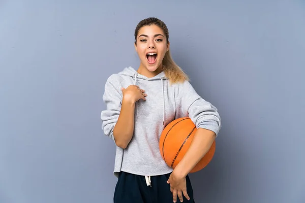 Teenager Mädchen Spielt Basketball Über Graue Wand Mit Überraschendem Gesichtsausdruck — Stockfoto
