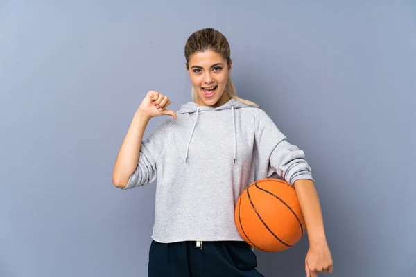 灰色の壁の上にバスケットボールをしているティーンエイジャーの女の子は誇りと自己満足 — ストック写真