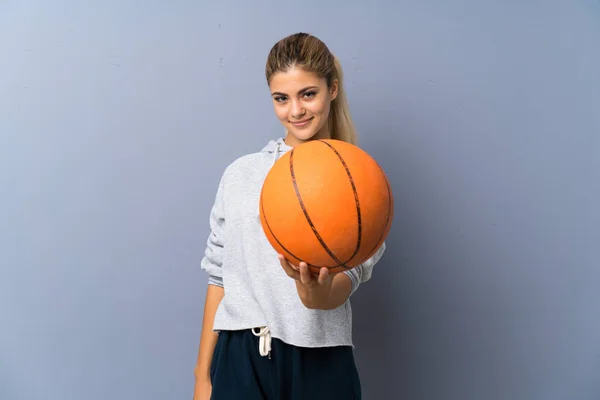 灰色の壁の上にバスケットボールをしているティーンエイジャーの女の子 — ストック写真